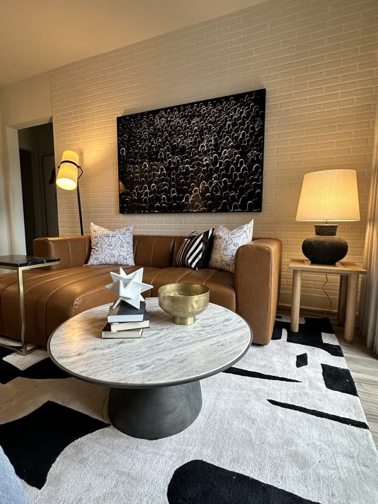 Model apartment at Margaux Midtown living room with modern furniture and brick walls
