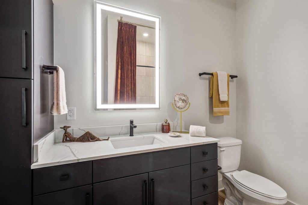 Modern apartment bathrooms with ample lighting at Margaux Midtown