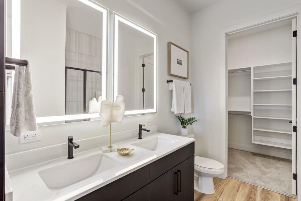 Modern apartment bathrooms that lead into walk-in closets in apartment homes at Margaux Midtown