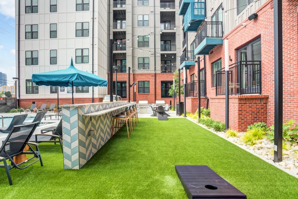 Gaming yard covered with turf featuring corn hole available to residents at Margaux Midtown