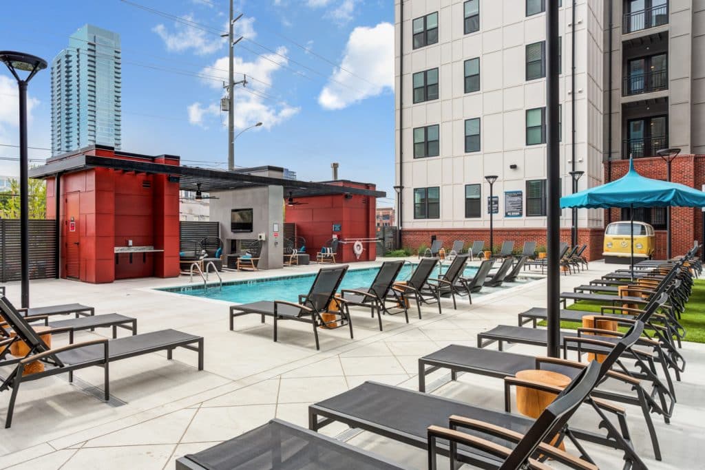 Community pool and ample lounge chair seating for residents at Margaux Midtown